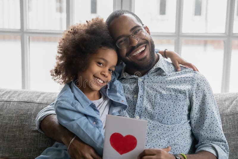 Porträt der glücklichen Vater- und Tochterkinderholdingpostkarte lizenzfreie stockfotografie