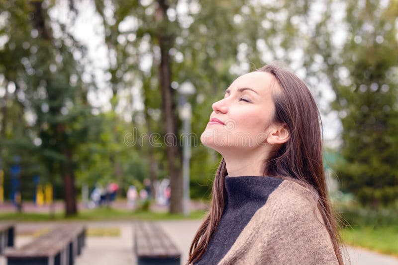 Porträt der jungen Schönheit Atem der frischen Herbstluft in einem grünen Park tuend das Konzept der reinen atmosphärischen Luft