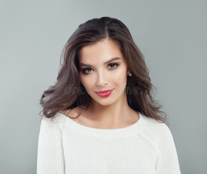 Porträt der netten brunette vorbildlichen Frau Nettes Mädchen, das auf grauem Hintergrund lächelt lizenzfreies stockbild