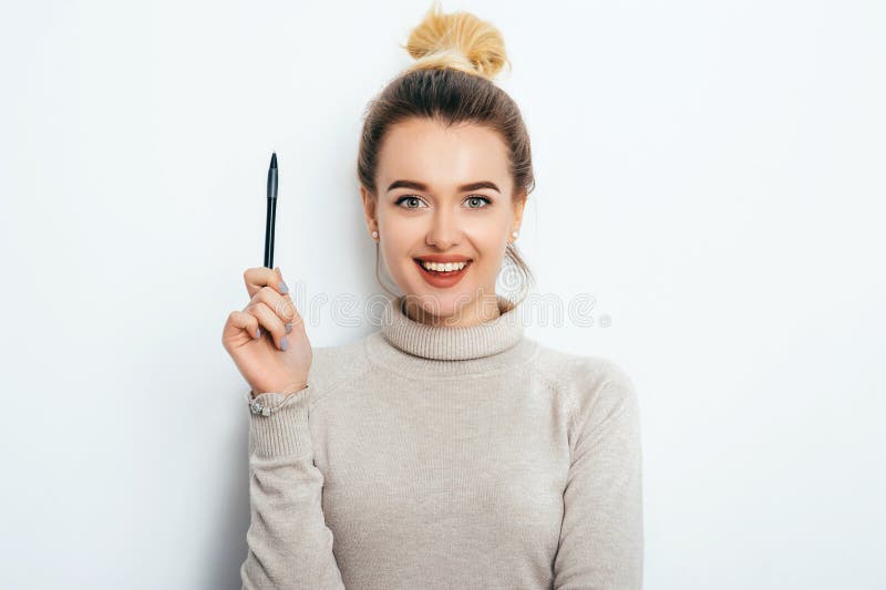 Porträt der netten Frau mit anziehendem Lächeln, Haarbrötchen in der Strickjacke essend, die auf weißem Hintergrundbehälter lokal lizenzfreies stockfoto