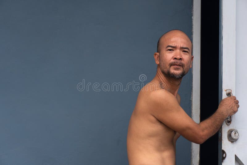 Porträt der offenen weißen Tür des düsteren Mannes des Bartes japanischen mit blauer Hausmauer stockfoto