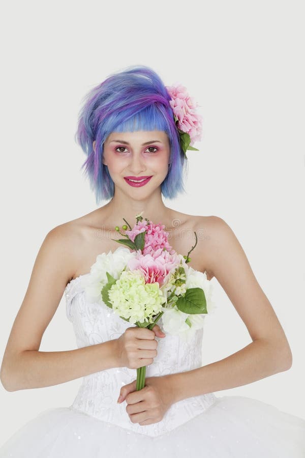 Porträt der schönen jungen Frau im Hochzeitskleid mit dem gefärbten Haar gegen grauen Hintergrund stockbild Porträt der schönen jungen Frau im Hochzeitskleid mit dem gefärbten Haar gegen grauen Hintergrund stockbild