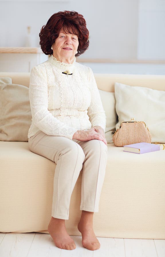 Porträt der schönen reifen Frau 80 Jahre alte Sitzen auf Sofa zu Hause lizenzfreie stockbilder Porträt der schönen reifen Frau 80 Jahre alte Sitzen auf Sofa zu Hause lizenzfreie stockbilder