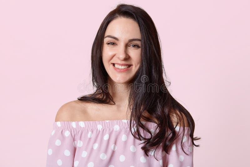 Porträt der Schönheit mit dem dunklen Haar, lächelt breit und ist in der guten Laune, gekleidet im Tupfenkleid, aufwirft gegen ro stockfotografie Porträt der Schönheit mit dem dunklen Haar, lächelt breit und ist in der guten Laune, gekleidet im Tupfenkleid, aufwirft gegen ro stockfotografie