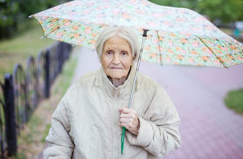 Porträt der älteren Frau unter Regenschirm stockfotos Porträt der älteren Frau unter Regenschirm stockfotos