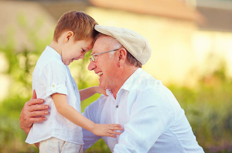 Porträt des glücklichen Großvaters und Enkel beugen ihre Köpfe