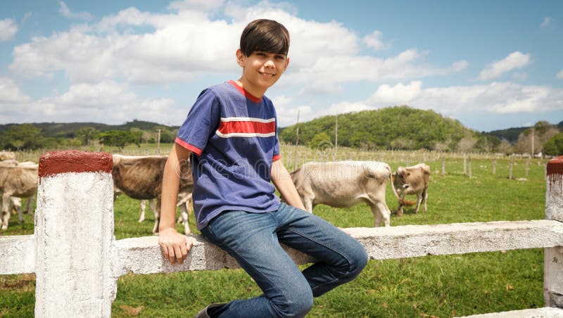 Porträt des glücklichen Jungen im Bauernhof mit Kühen in der Ranch lizenzfreie stockfotos Porträt des glücklichen Jungen im Bauernhof mit Kühen in der Ranch lizenzfreie stockfotos