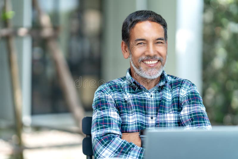 Porträt des glücklichen reifen Mannes mit dem weißen, grauen stilvollen kurzen Bart, der die Kamera im Freien betrachtet Zufällig