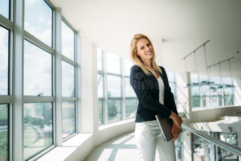 Porträt des jungen busineswoman stehend in der Bürolobby lizenzfreie stockfotografie Porträt des jungen busineswoman stehend in der Bürolobby lizenzfreie stockfotografie