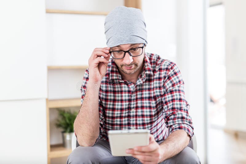 Porträt des jungen Hippie-Geschäftsmannes, der im Büro sitzt und digitale Tablette verwendet lizenzfreies stockfoto Porträt des jungen Hippie-Geschäftsmannes, der im Büro sitzt und digitale Tablette verwendet lizenzfreies stockfoto