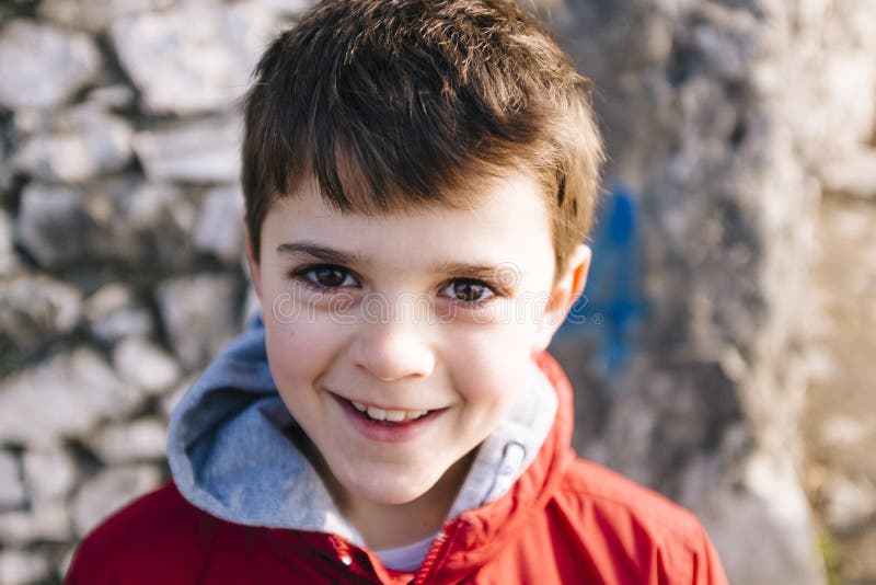 Porträt des Jungen mit 9-Jährigen mit roter Jacke draußen