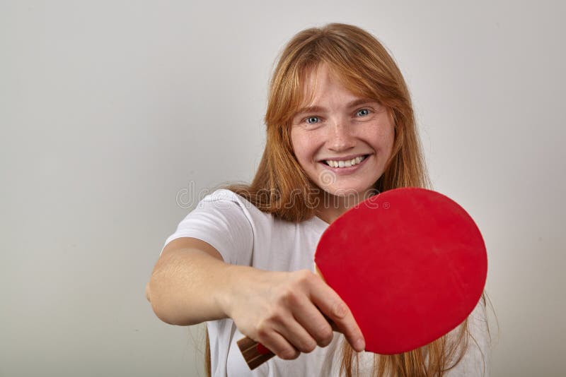 Porträt des jungen Mädchens mit dem roten Haar und den Sommersprossen kleidete im weißen T-Shirt an, das Tischtennisschläger hält stockbilder Porträt des jungen Mädchens mit dem roten Haar und den Sommersprossen kleidete im weißen T-Shirt an, das Tischtennisschläger hält stockbilder