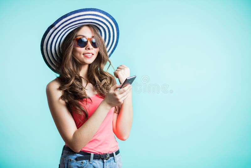 Porträt des lächelnden Mädchens im Hut und in der Sonnenbrille, nette schöne junge Frau, die durch den Handy lokalisiert plaudert stockfotos Porträt des lächelnden Mädchens im Hut und in der Sonnenbrille, nette schöne junge Frau, die durch den Handy lokalisiert plaudert stockfotos