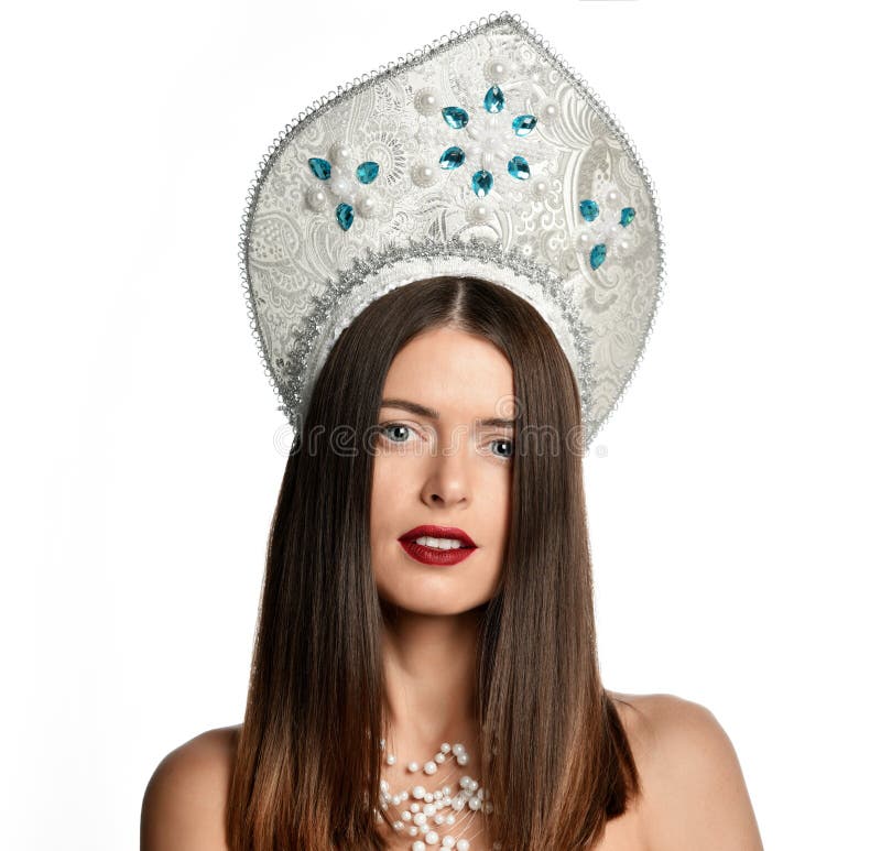 Porträt des Modells des jungen Mädchens in kokoshnik Hut mit natürlichem Make-up und langen Schlagdem haar lokalisiert Betrachten lizenzfreies stockbild Porträt des Modells des jungen Mädchens in kokoshnik Hut mit natürlichem Make-up und langen Schlagdem haar lokalisiert Betrachten lizenzfreies stockbild