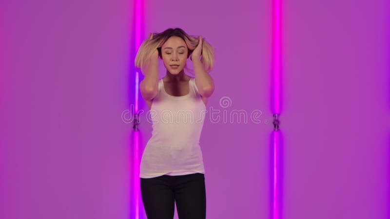Porträt des modernen Modells flirtatiously Tanzens und stellen für die Kamera. junge Blondine in der weißen Gelegenheitsarbeit Spi stock video