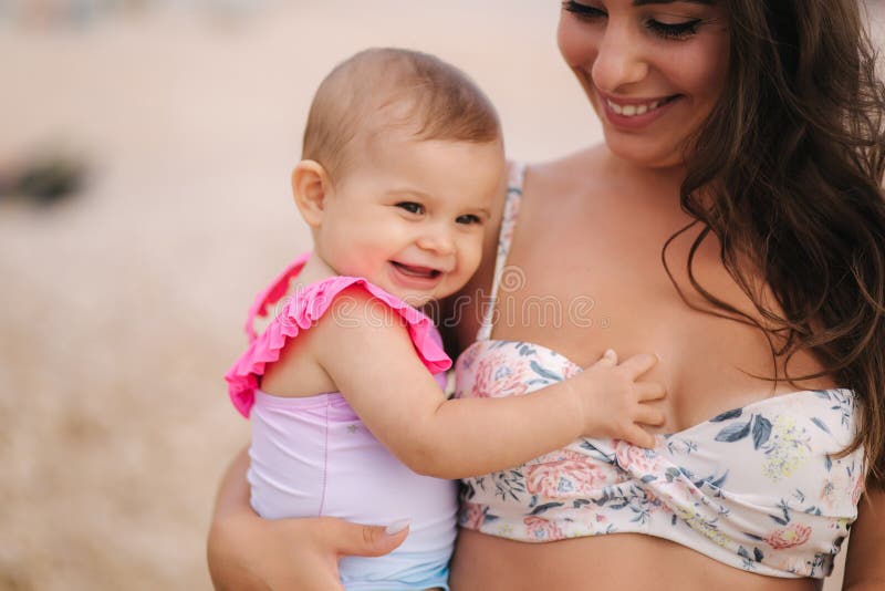 Porträt des Muttergriffbabys auf Händen auf dem Strand im Meer Mutter und Tochter im Badeanzug Schlie?en Sie oben von sch?nem stockbilder Porträt des Muttergriffbabys auf Händen auf dem Strand im Meer Mutter und Tochter im Badeanzug Schlie?en Sie oben von sch?nem stockbilder