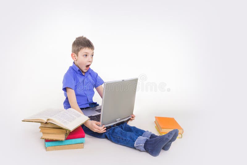 Porträt des netten Schülers sitzend mit Büchern und auf Laptoptastatur schreibend lizenzfreie stockfotos Porträt des netten Schülers sitzend mit Büchern und auf Laptoptastatur schreibend lizenzfreie stockfotos