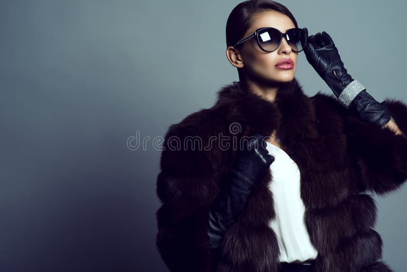 Porträt des schönen bezaubernden vorbildlichen tragenden Zobelmantels, der Sonnenbrille, der Handschuhe und des Schmucks stockfotografie Porträt des schönen bezaubernden vorbildlichen tragenden Zobelmantels, der Sonnenbrille, der Handschuhe und des Schmucks stockfotografie