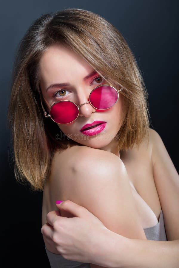 Porträt des schönen Mädchens in den runden rosa Gläsern lizenzfreie stockfotos