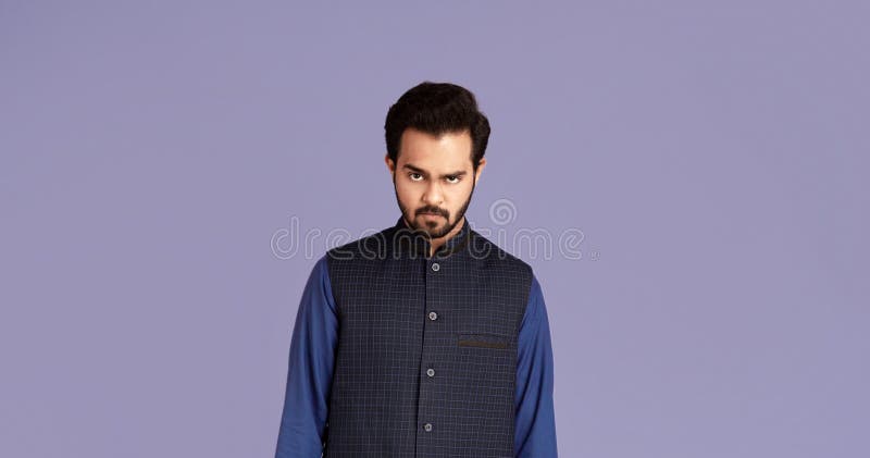Porträt des strengen indischen Mann in der traditionellen Kleidung auf violettem Hintergrund