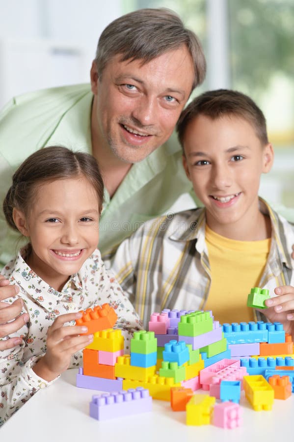 Porträt des Vaters und der Kinder, die mit bunter Plastikquerstation spielen lizenzfreie stockfotografie Porträt des Vaters und der Kinder, die mit bunter Plastikquerstation spielen lizenzfreie stockfotografie