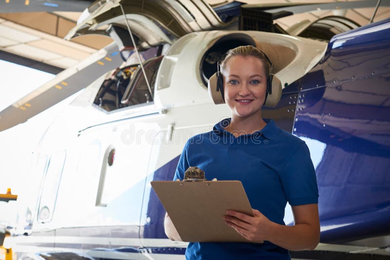 Porträt des weiblichen Aero Ingenieurs With Clipboard Carrying heraus Che lizenzfreies stockbild Porträt des weiblichen Aero Ingenieurs With Clipboard Carrying heraus Che lizenzfreies stockbild