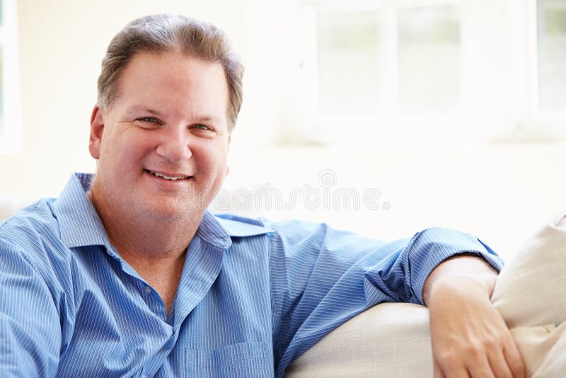 Portrait Of Overweight Man Sitting On Sofa. Portrait Of Overweight Man Sitting On Sofa