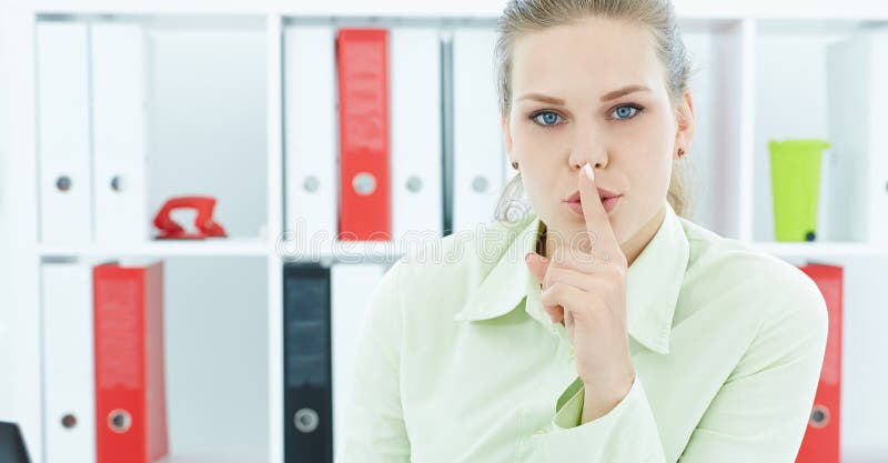 Porträt einer attraktiven Geschäftsfrau mit dem Finger auf Lippen Junge Geschäftsfrau im Büro bitten um Ruhe