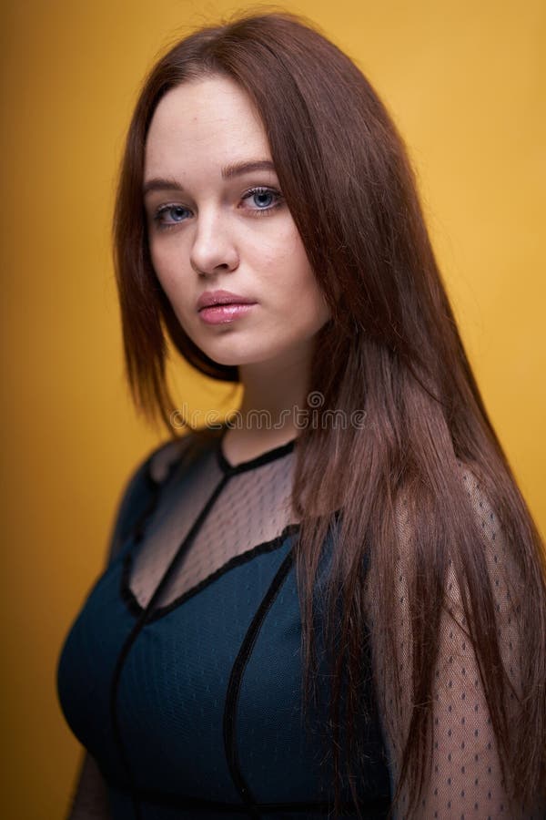 Porträt einer Frau in einem farbigen Kleid auf gelbem Hintergrund lizenzfreies stockfoto