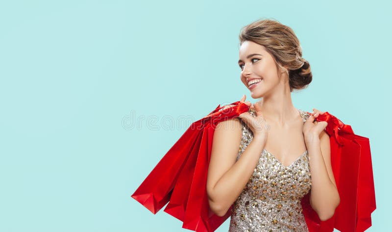 Porträt einer glücklichen charmanten Frau mit roten Einkaufstüten. blauer Hintergrund lizenzfreie stockfotografie