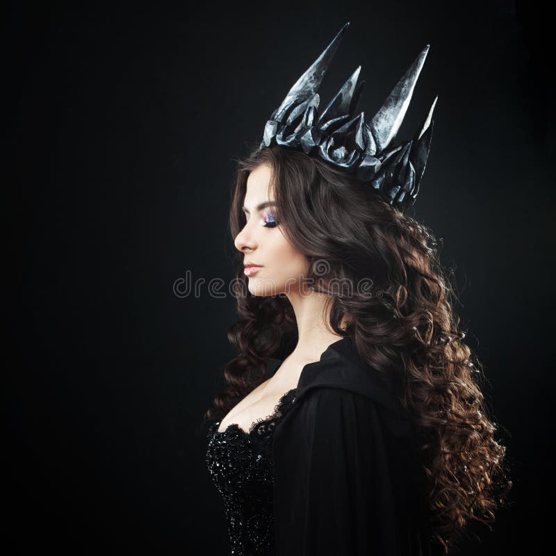 Porträt einer gotischen Prinzessin Schöne junge Brunettefrau in der Metallkrone und im schwarzen Mantel lizenzfreies stockfoto Porträt einer gotischen Prinzessin Schöne junge Brunettefrau in der Metallkrone und im schwarzen Mantel lizenzfreies stockfoto