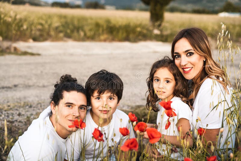 Porträt einer jungen Familie lächelnd und glücklich, die Kamera auf der Außenseite betrachtend lizenzfreies stockbild Porträt einer jungen Familie lächelnd und glücklich, die Kamera auf der Außenseite betrachtend lizenzfreies stockbild
