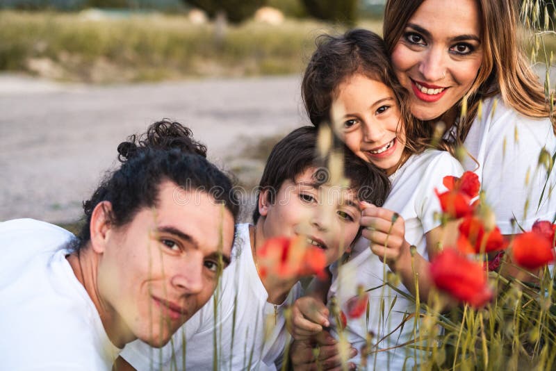 Porträt einer jungen Familie lächelnd und glücklich, die Kamera auf der Außenseite betrachtend lizenzfreie stockfotos Porträt einer jungen Familie lächelnd und glücklich, die Kamera auf der Außenseite betrachtend lizenzfreie stockfotos