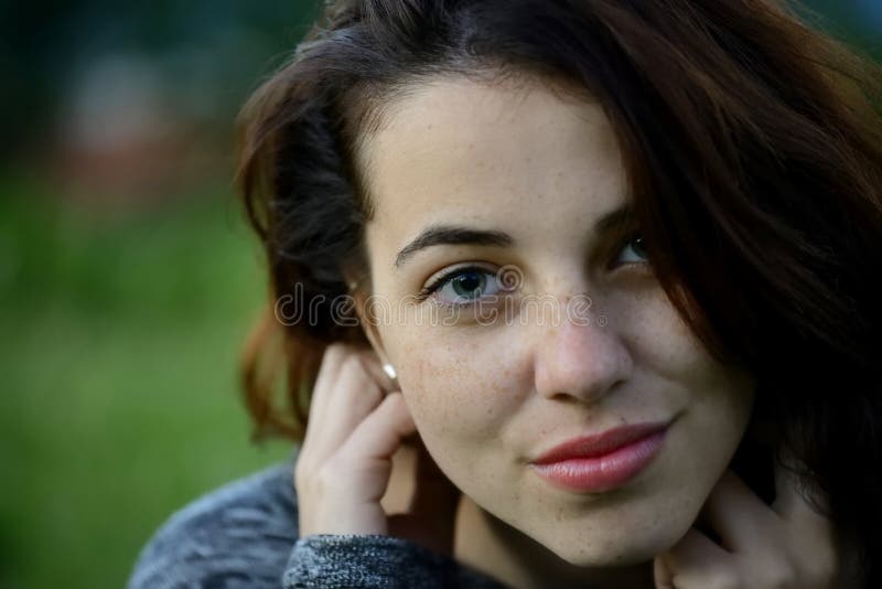 Porträt einer jungen sommersprossigen jungen Frau mit Gebirgshintergrund lizenzfreies stockbild Porträt einer jungen sommersprossigen jungen Frau mit Gebirgshintergrund lizenzfreies stockbild
