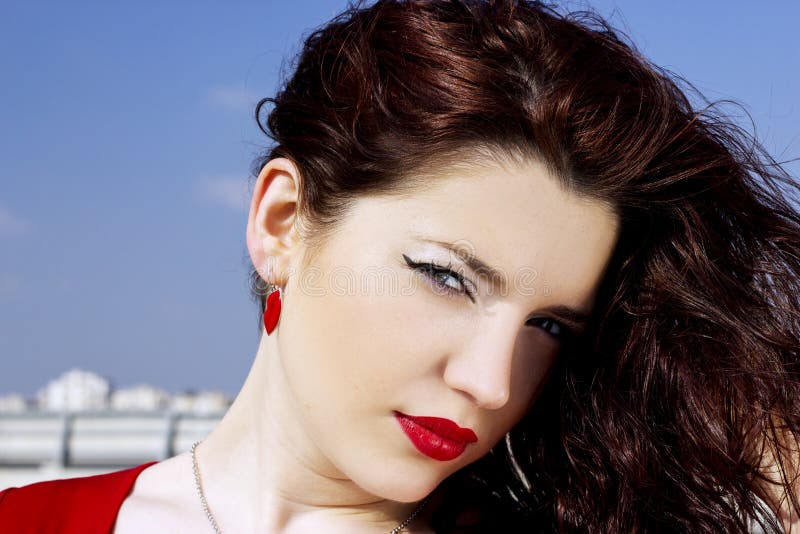 Porträt eines bezaubernden hübschen Mädchens mit dem langen roten Haar Eine hübsche Frau, die auf einem Hintergrund einer Sommern lizenzfreies stockbild Porträt eines bezaubernden hübschen Mädchens mit dem langen roten Haar Eine hübsche Frau, die auf einem Hintergrund einer Sommern lizenzfreies stockbild