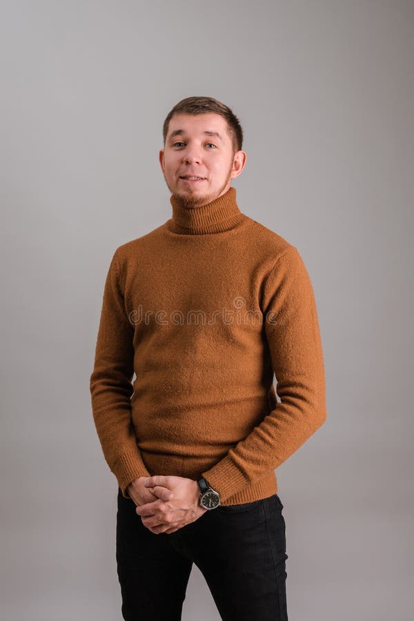 Porträt eines bärtigen Mannes in einem roten Pullover auf grauem Hintergrund stockfoto