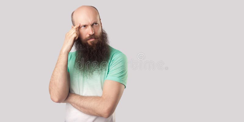 Porträt eines gedankenvollen Glatzköpfers mittleren Alters mit langem Bart in hellgrünem T-Shirt, das steht und wegschaut, denkt