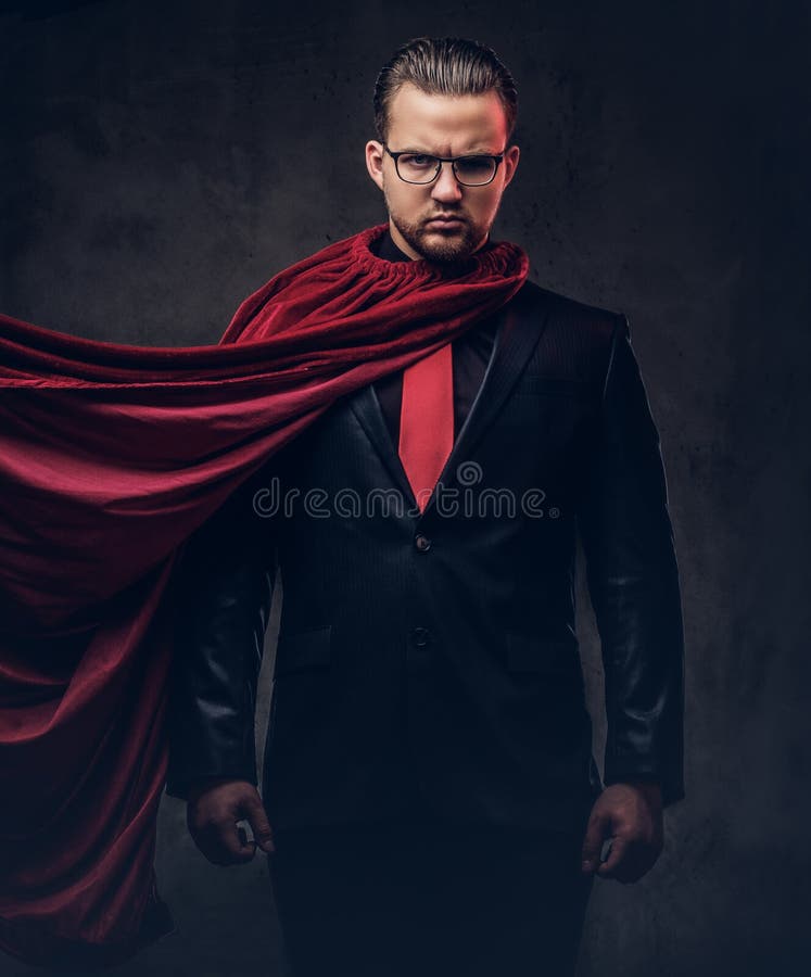 Porträt eines Geniesuperhelden in einem schwarzen Anzug mit einer roten Bindung auf einem dunklen Hintergrund lizenzfreie stockbilder Porträt eines Geniesuperhelden in einem schwarzen Anzug mit einer roten Bindung auf einem dunklen Hintergrund lizenzfreie stockbilder