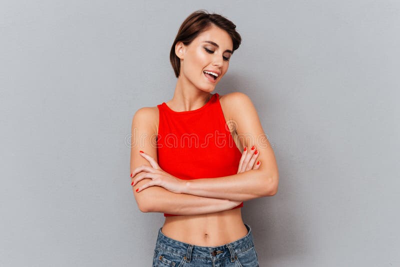 Porträt eines lächelnden netten Brunettemädchens mit den Händen gekreuzt lizenzfreies stockbild