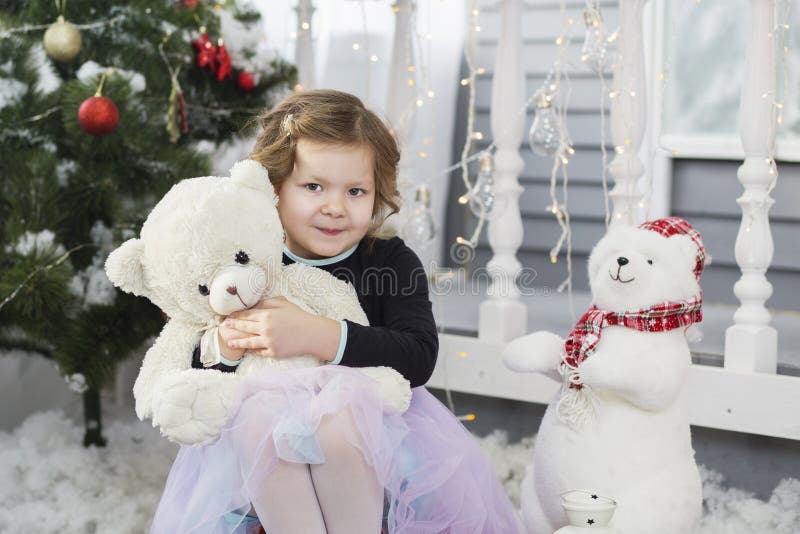 Porträt eines netten kleinen Mädchens, das einen weichen Teddybären umarmt lizenzfreie stockfotografie