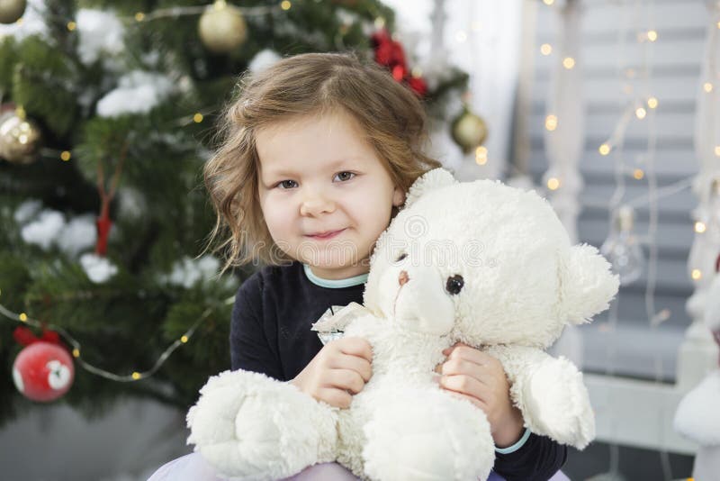 Porträt eines netten kleinen Mädchens, das einen weichen Teddybären umarmt lizenzfreie stockbilder