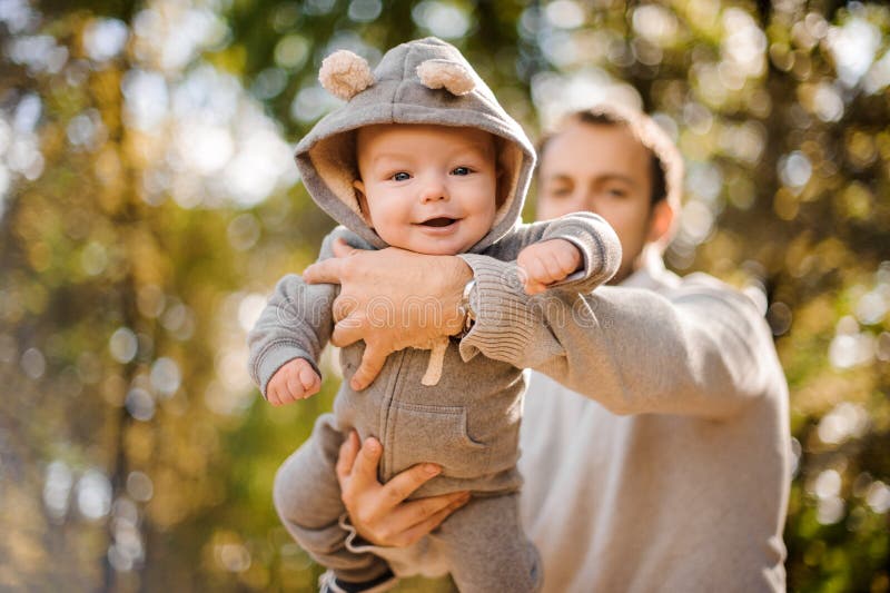 Porträt eines netten lächelnden Babys in den Vaterhänden stockbild Porträt eines netten lächelnden Babys in den Vaterhänden stockbild