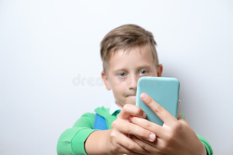 Porträt eines netten Schülers mit blauem Rucksack und intelligentem Telefon stockbilder Porträt eines netten Schülers mit blauem Rucksack und intelligentem Telefon stockbilder