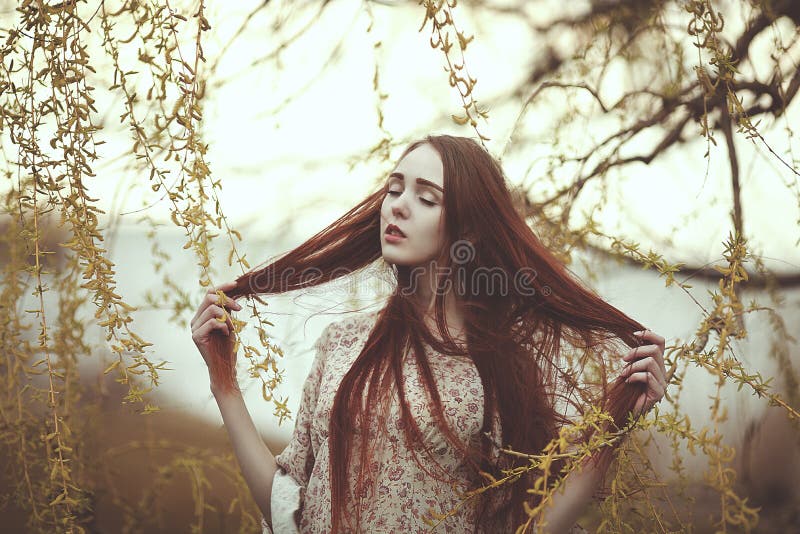 Porträt eines romantischen Mädchens mit dem roten Haar im Wind unter einem Weidenbaum lizenzfreie stockfotos Porträt eines romantischen Mädchens mit dem roten Haar im Wind unter einem Weidenbaum lizenzfreie stockfotos