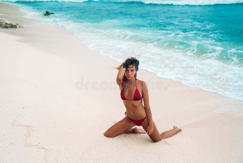 Porträt eines sexy gebräunten Mädchens auf dem Strand Ein herrliches Modell mit eng anliegender Sport erscheinen in einem roten B lizenzfreie stockbilder Porträt eines sexy gebräunten Mädchens auf dem Strand Ein herrliches Modell mit eng anliegender Sport erscheinen in einem roten B lizenzfreie stockbilder