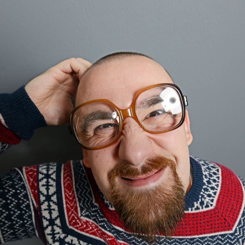 Porträt eines Sonderlings mit Gläsern und Retro- Strickjacke gegen grauen Hintergrund stockbilder Porträt eines Sonderlings mit Gläsern und Retro- Strickjacke gegen grauen Hintergrund stockbilder