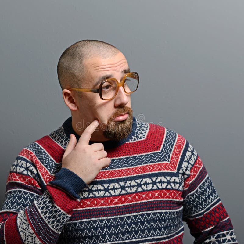 Porträt eines Sonderlings mit Gläsern und Retro- Strickjacke gegen grauen Hintergrund stockfotografie Porträt eines Sonderlings mit Gläsern und Retro- Strickjacke gegen grauen Hintergrund stockfotografie