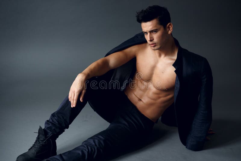Portr?t eines ?berzeugten, sexy jungen Mannes, mit dem nackten Torso mit Jacke auf seinen Schultern, lokalisiert auf grauem Hinte lizenzfreie stockbilder Portr?t eines ?berzeugten, sexy jungen Mannes, mit dem nackten Torso mit Jacke auf seinen Schultern, lokalisiert auf grauem Hinte lizenzfreie stockbilder