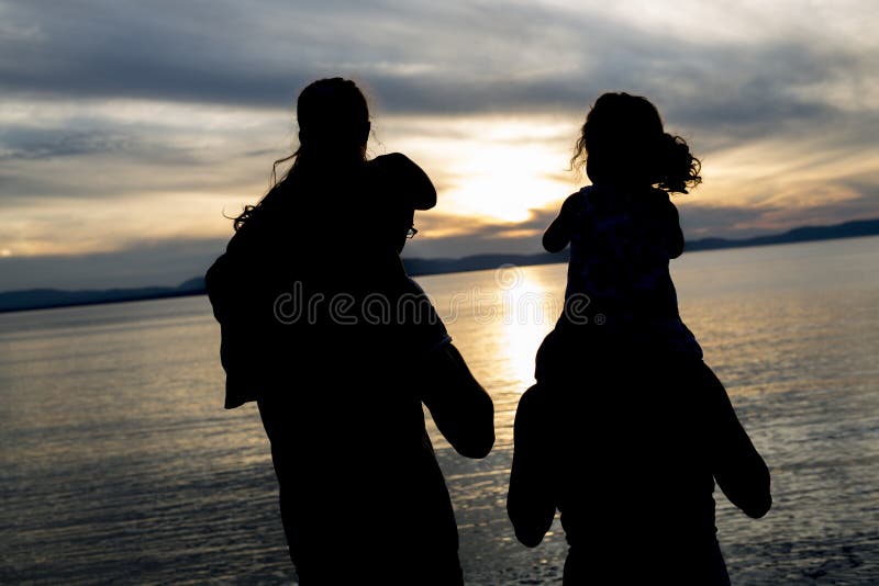 Porträt glücklicher schöner Familie vier zusammen bei Sonnenuntergang lizenzfreies stockbild Porträt glücklicher schöner Familie vier zusammen bei Sonnenuntergang lizenzfreies stockbild