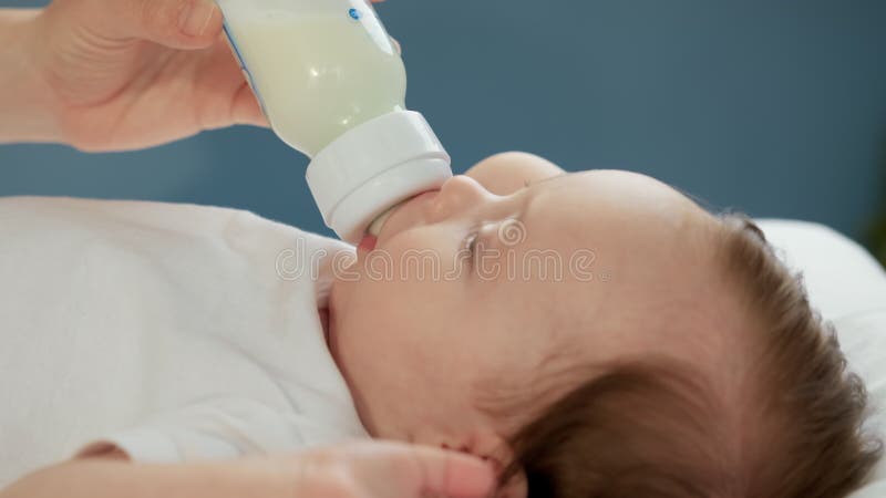 Porträt Kleinkind trinken verdünntes Milchpulver. Konzept der Mutterschaft und der Kindheit. kaukasisches Neugeborenes